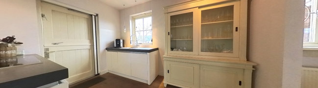 Fijne keuken om lekker te koken, met kookeiland en twee wandopstellingen. Een authentieke staldeur geeft toegang tot het terras.