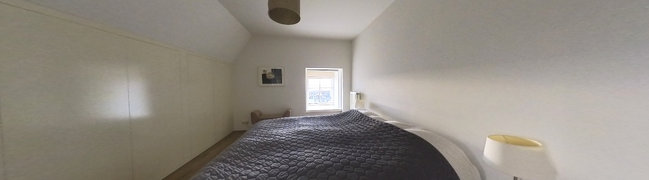 Slaapkamer met vaste kastenwanden en diepe vensterbank.