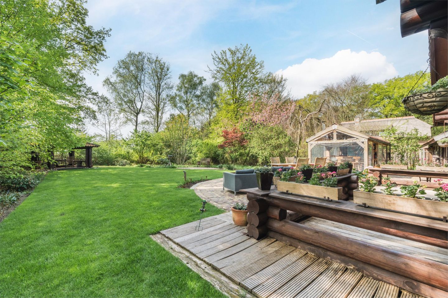 De tuin met gras en bomen er omheen