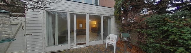 Achtertuin met tuinhuisje en poortdeur opzij